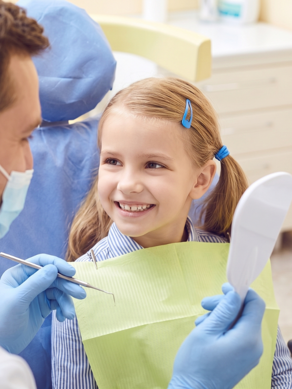 picture of a young girl smiling up at a myofunctional therapist in Reno, NV